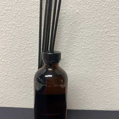 Amber glass bottle with black reed sticks