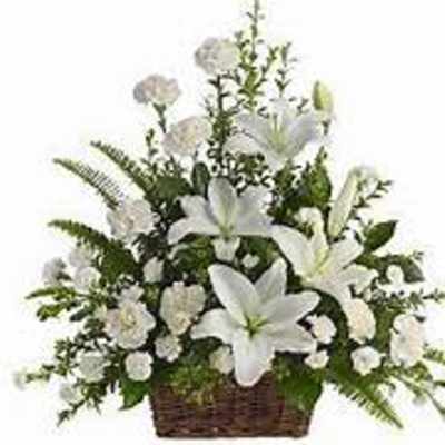 White lilies and carnations arranged in a wicker basket