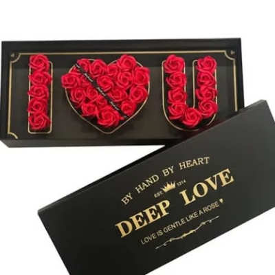 Black gift box with red roses arranged to spell I heart U