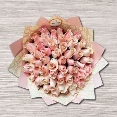 Bouquet of pale pink roses wrapped in patterned paper
