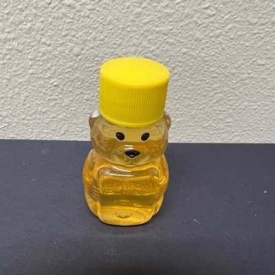Small bear-shaped honey bottle with a yellow cap
