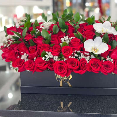 Red roses in a black rectangular box with white orchids