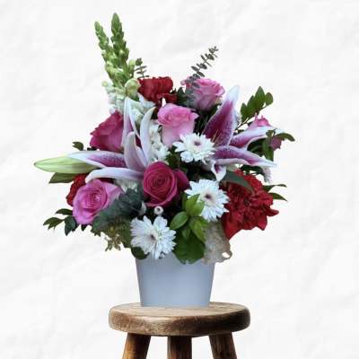 Pink roses and lilies arranged in a light blue vase