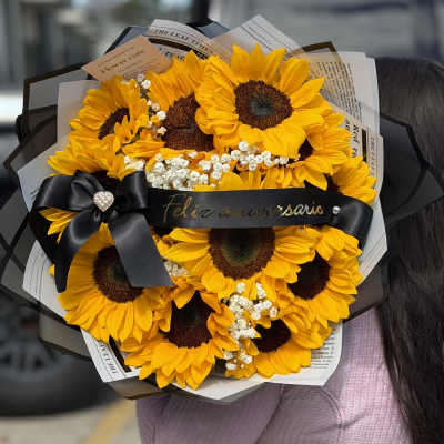 Bouquet of bright yellow sunflowers with a black ribbon bow