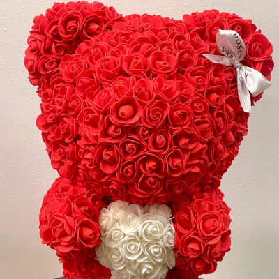 Red teddy bear made of roses with a white rose heart on its chest