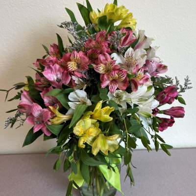 Bouquet of pink, white, and yellow alstroemeria in a glass vase