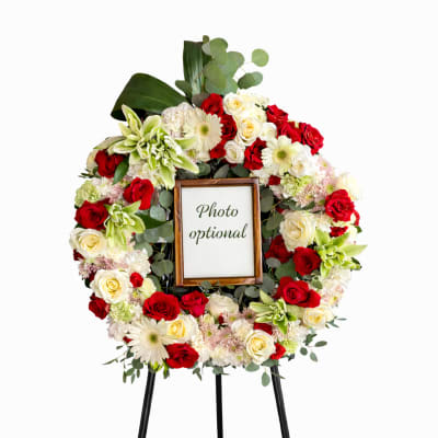 Floral wreath on a stand with a photo frame in the center