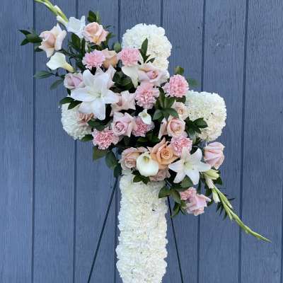 Cross-shaped floral spray with white and pink flowers on a stand