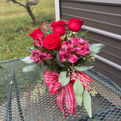 Bouquet of red roses and pink flowers with a plaid ribbon