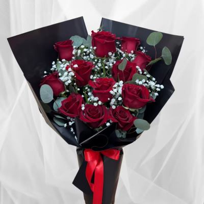 Bouquet of red roses with baby's breath wrapped in black paper and a red ribbon