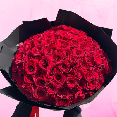 Large bouquet of red roses wrapped in black paper
