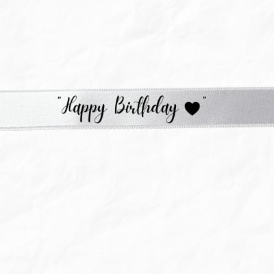 White ribbon with "Happy Birthday" text and a black heart