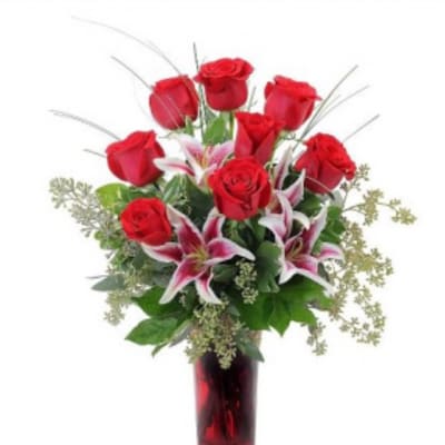 Red roses and pink lilies in a red glass vase