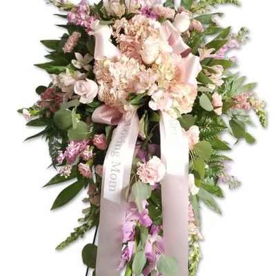 Tall pink and white sympathy spray on a stand with ribbon