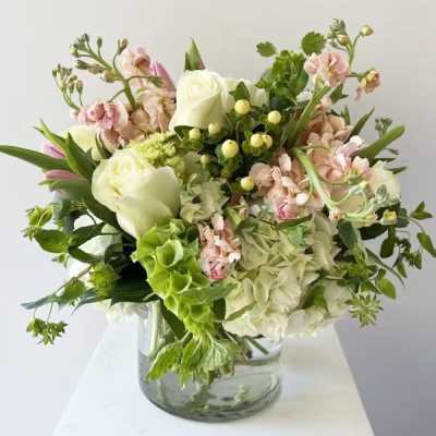 Bouquet of white and pale pink flowers in a clear glass vase
