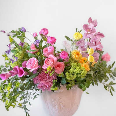 Large mixed bouquet in a pink vase with pink, yellow, and purple flowers