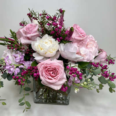 Pink and white floral arrangement in a square glass vase