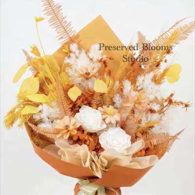 Tall bouquet of orange and yellow dried flowers with white roses wrapped in orange paper with ribbon