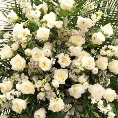 Large white rose funeral spray with greenery