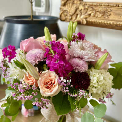 Pink and white mixed bouquet in a glass vase with a burlap ribbon