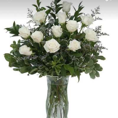 White roses arranged in a clear glass vase