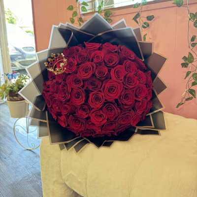 Large bouquet of red roses wrapped in black paper