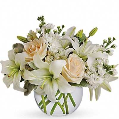 White lilies and cream roses arranged in a round vase