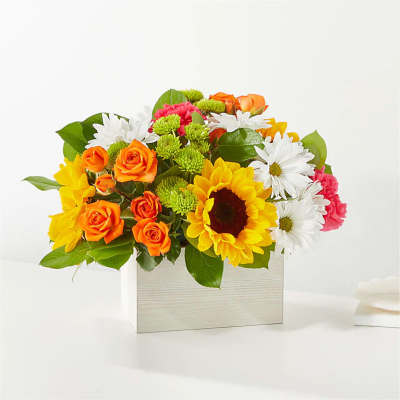 Bright mixed bouquet in a rectangular wooden box