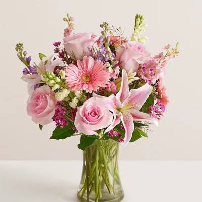 Pink mixed bouquet with roses and lilies in a clear glass vase