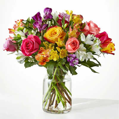 Mixed bouquet of roses and alstroemeria in a clear glass vase