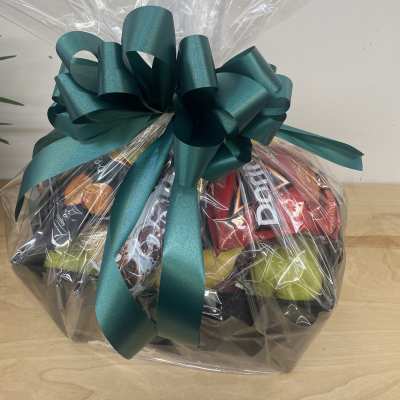 Gift basket wrapped in clear cellophane with a teal bow