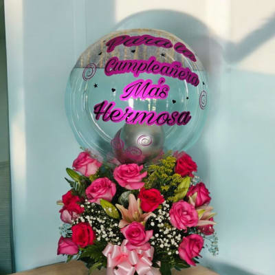 Pink rose arrangement with a clear balloon and Spanish birthday message