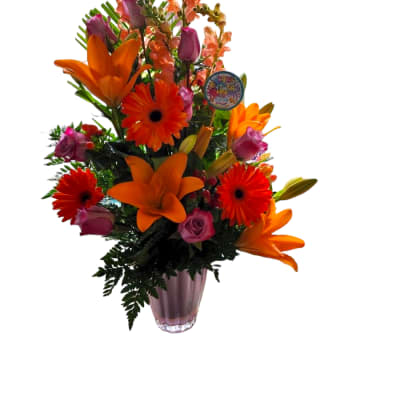 Tall bouquet of orange lilies, gerbera daisies, and pink roses in a glass vase