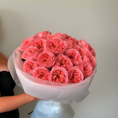 Bouquet of bright pink roses wrapped in pale paper