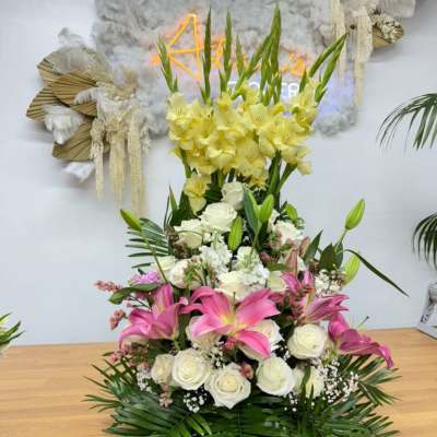Tall floral arrangement with pink lilies, white roses, and yellow flowers