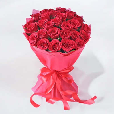 Bouquet of red roses wrapped in pink paper with a ribbon