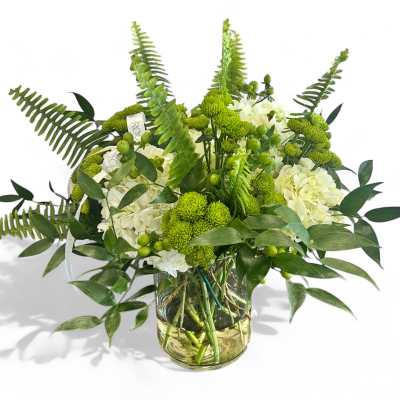 Green and white floral arrangement in a glass vase