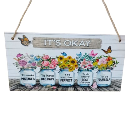 Decorative hanging sign with painted flower jars and the words "IT'S OKAY"
