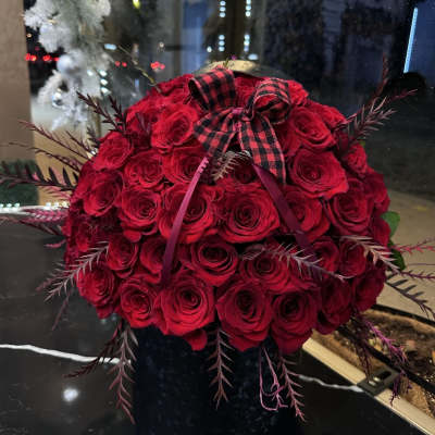 Red rose bouquet with a plaid bow in a black vase