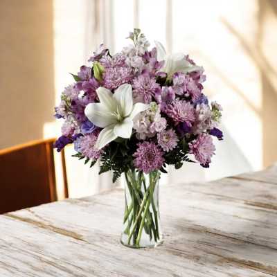 Purple and white bouquet in a clear glass vase