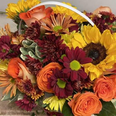 Bouquet of orange roses, sunflowers, and burgundy daisies
