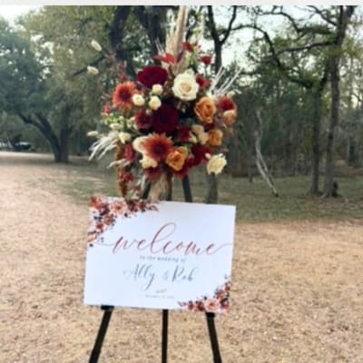 Floral arrangement on an easel beside a welcome sign
