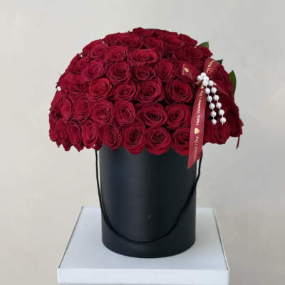 Red rose bouquet in a black hatbox with a Valentine ribbon