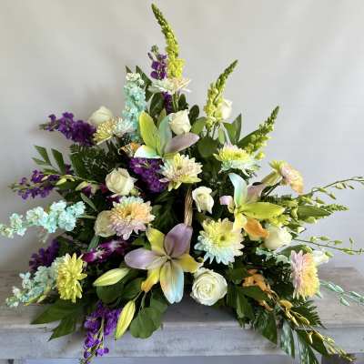 Large mixed floral arrangement with white roses and pastel blooms