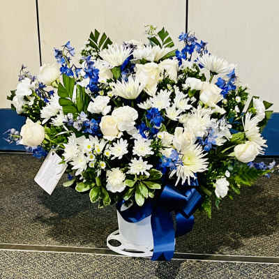 White roses and chrysanthemums with blue flowers in a white vase