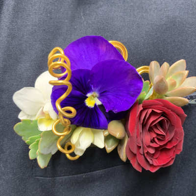 Floral wrist corsage with purple pansy, red rose, and succulents