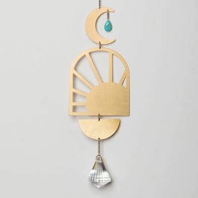 Gold-toned hanging sun and moon suncatcher with turquoise charm and clear faceted crystal.