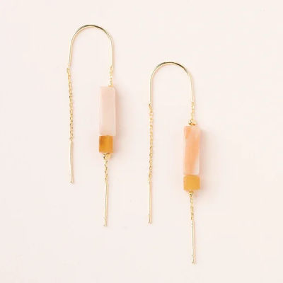Pair of gold threader earrings with peach rectangular stones on a light background