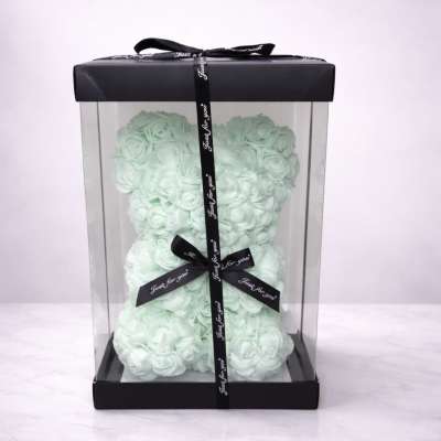 Mint rose-shaped teddy bear in a clear gift box with black ribbon