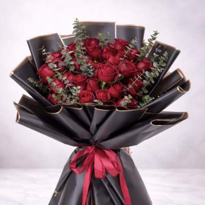 Bouquet of red roses wrapped in black paper with a red ribbon